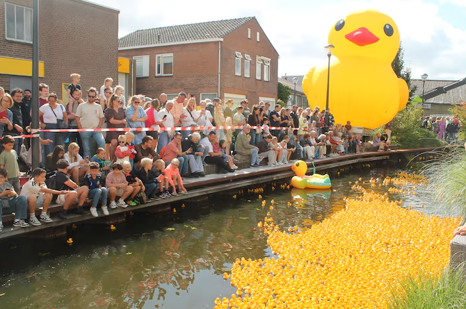 Reuze geel badeendje bij de finish met massa publiek op de kade