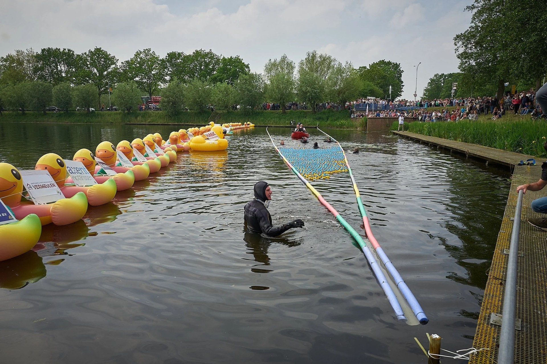 Reuzeenden met sponsorborden op het water tijdens de race